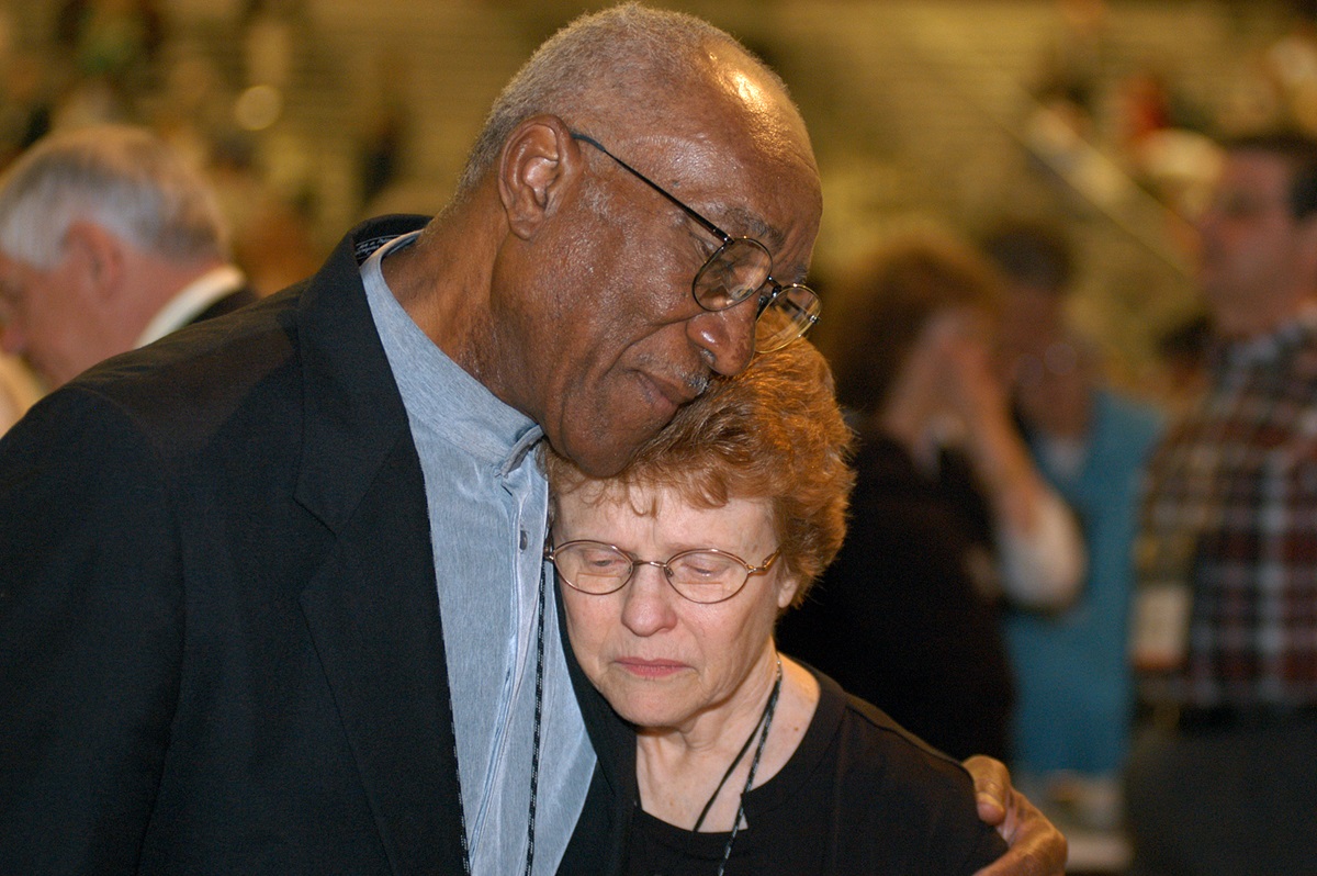 Delegates Burnham A. Robinson (left) and Rev. Judith A. Sands, both from Central Texas, embrace following a vote of the 2004 General Conference in Pittsburgh affirming unity in the United Methodist Church. The overwhelming approval of the resolution on unity followed several days of contentious debate on the issues in the church related to homosexuality. A UMNS photo by John C. Goodwin.