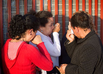 Mothers who are separated from their families in the U.S. cry at the Mexican side of the border wall between San Diego and Tijuana, Mexico, during the Posada Without Borders.