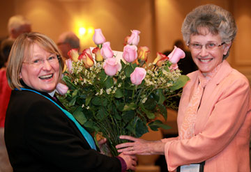 Bishop Wenner (left) receives roses from Bishop Peggy Johnson of the Philadelphia Area in congratulations of becoming the new president of the Council of Bishops.