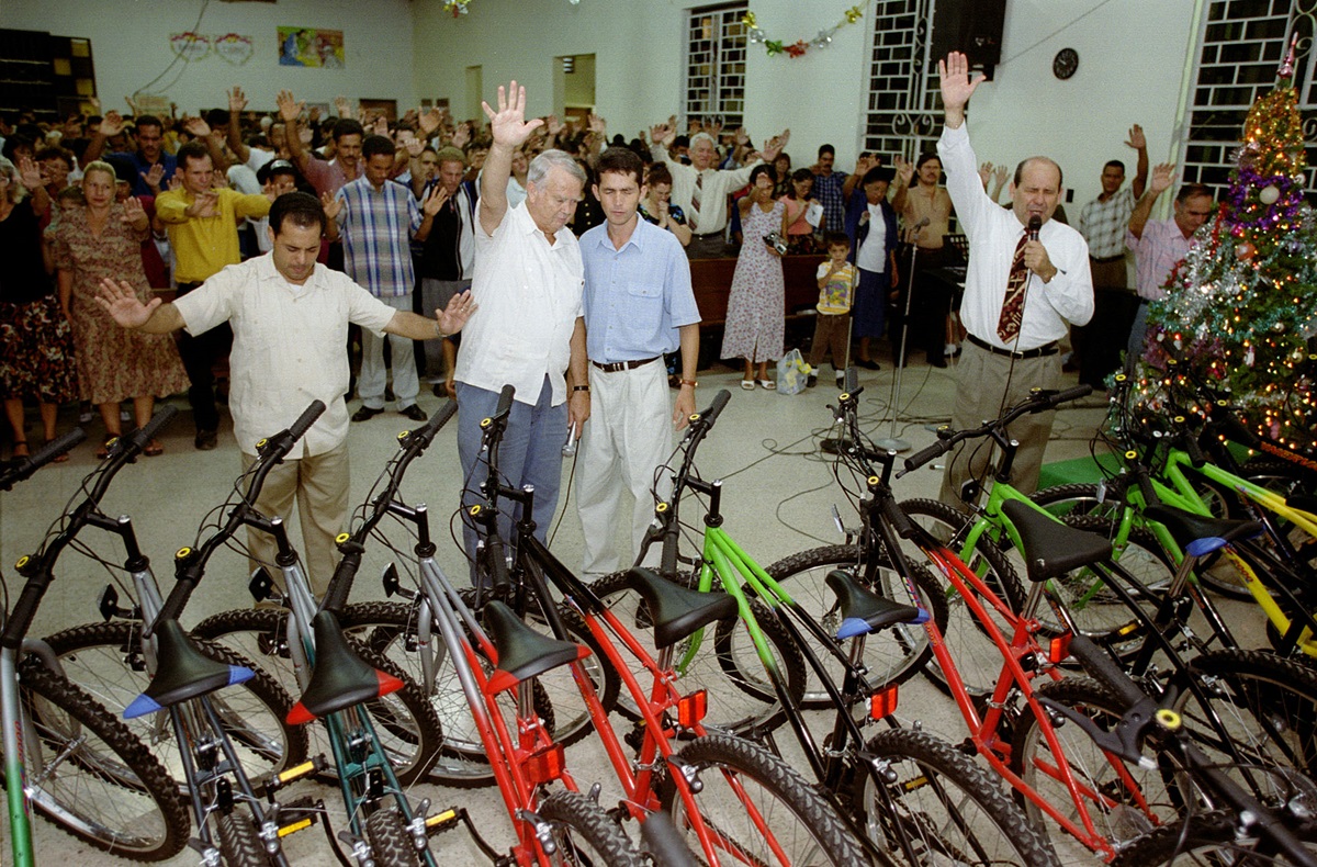 The Rev. H. Eddie Fox (second from left) and Bishop Ricardo Pereira Diaz of the Methodist Church in Cuba (right) bless bicycles donated by World Methodist Evangelism to Cuban lay pastors during a service at J.W. Branscomb Methodist Church in Holguin, Cuba in 2002.