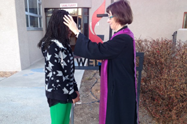 La Rda. Kim Kinsey ofrece cenizas a una joven en la acera exterior de la Iglesia Metodista Unida Cristo en Albuquerque, Nuevo México. Foto cortesía de la Rvda. Kim Kinsey.