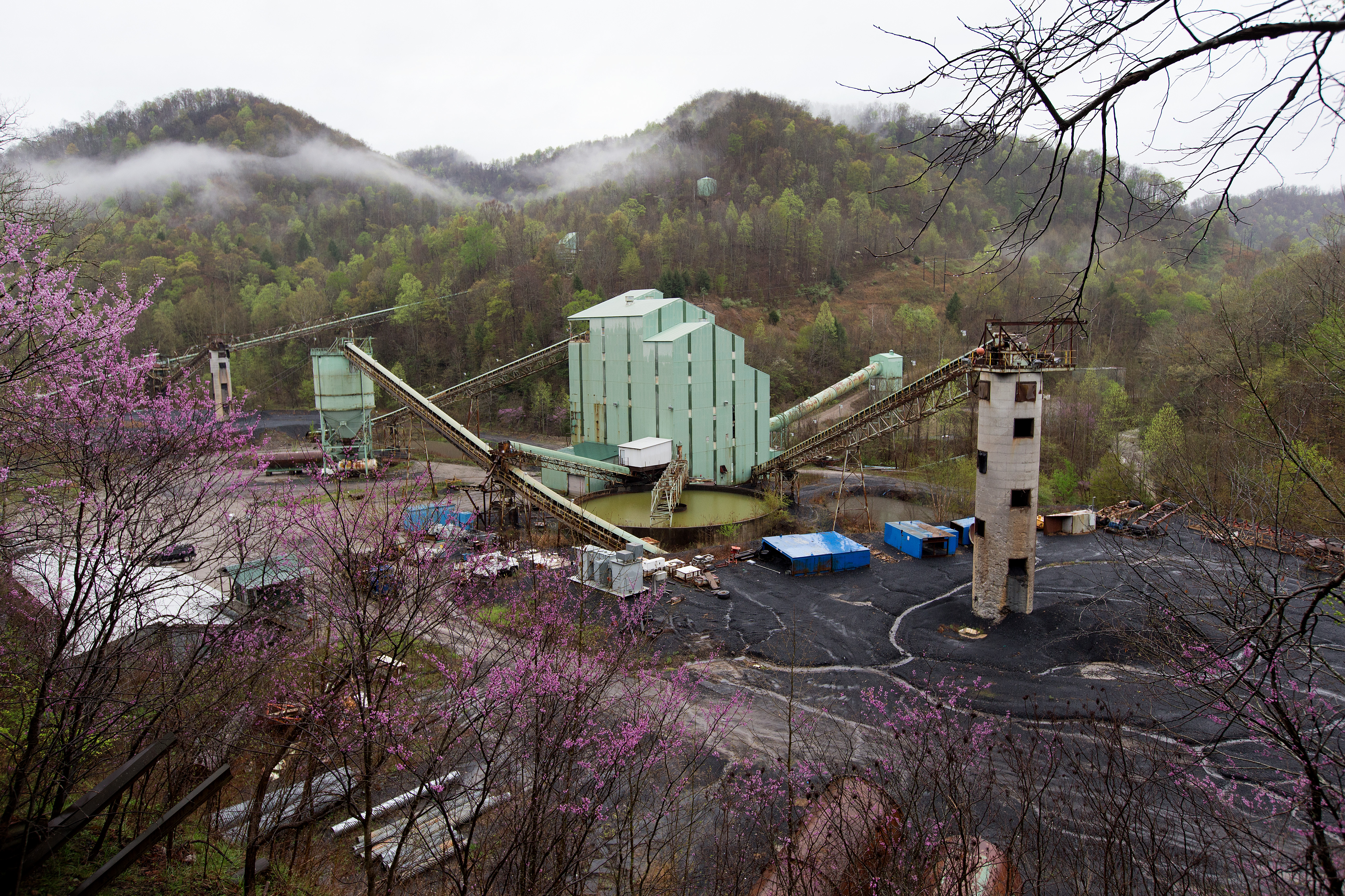 Morning fog rises in the mountains behind a decommissioned coal washing plant near Beverly, Ky. 