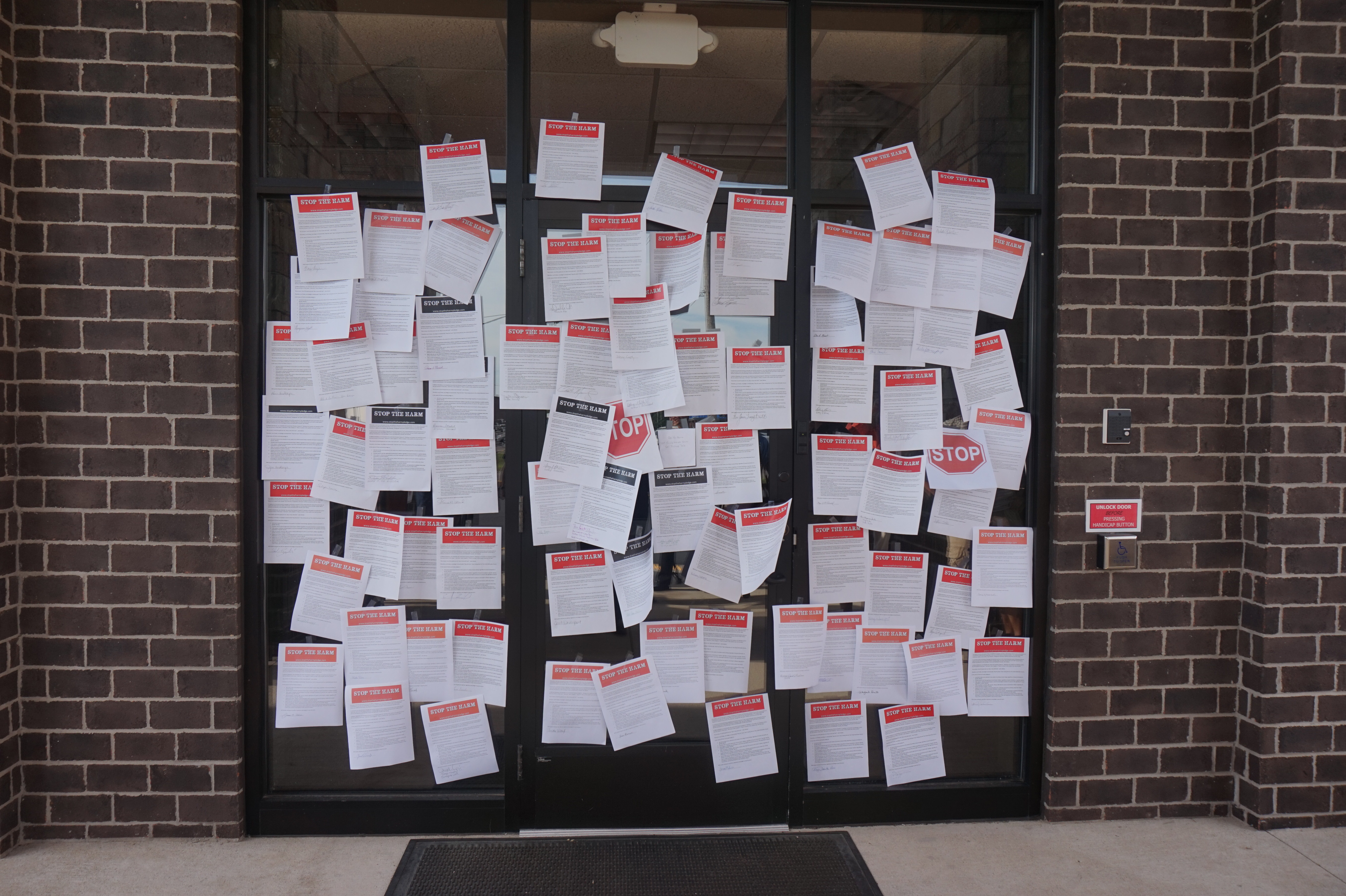 Petitions supporting changing the church’s stance on homosexuality are taped to a bishop’s door  in a demonstration meant to invoke Martin Luther’s famous posting of the 95 Theses to the Wittenberg Castle Church door. Photo courtesy of Reconciling Ministries Network