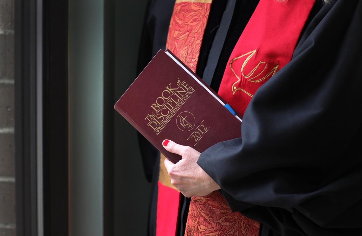 The 2012 Book of Discipline of The United Methodist Church is held by an ordained elder. General Conference is expected to debate what church teaches about ministry with gay individuals. Photo illustration by Kathleen Barry, United Methodist Communications