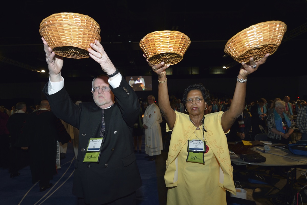 A woman and man hold high collection baskets during the offering in the April 24 opening worship service of the 2012 United Methodist General Conference in Tampa, Fla.  Giving and the church budget are topics that the 2016 General Conference takes up when it meets in May. File photo by Paul Jeffrey, UMNS.