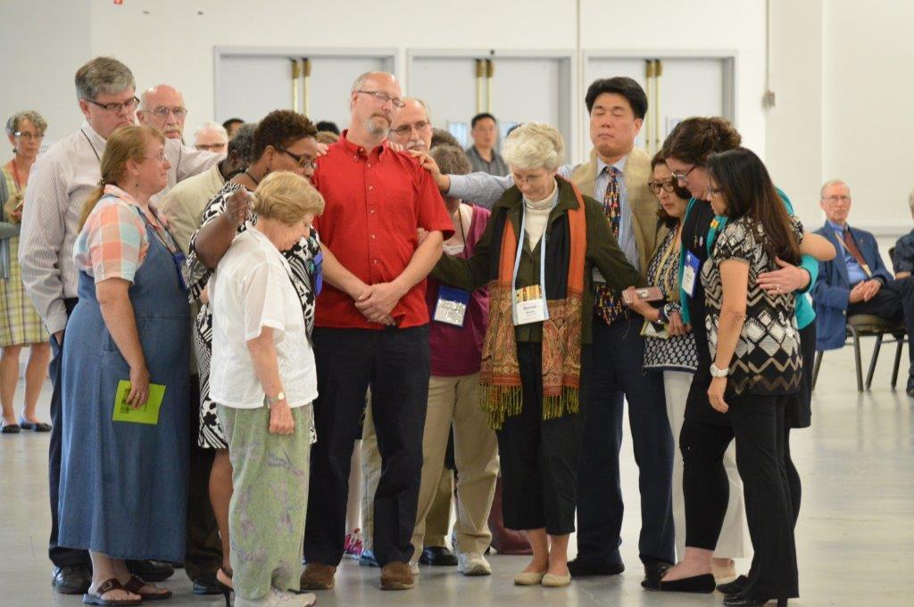 Church members stand with the Rev. Donald “Skip” Smith, who said he would leave the New England Conference after the non-conformity vote. He later told his district superintendent that he would stay. Photo by Beth DiCocco, New England Conference