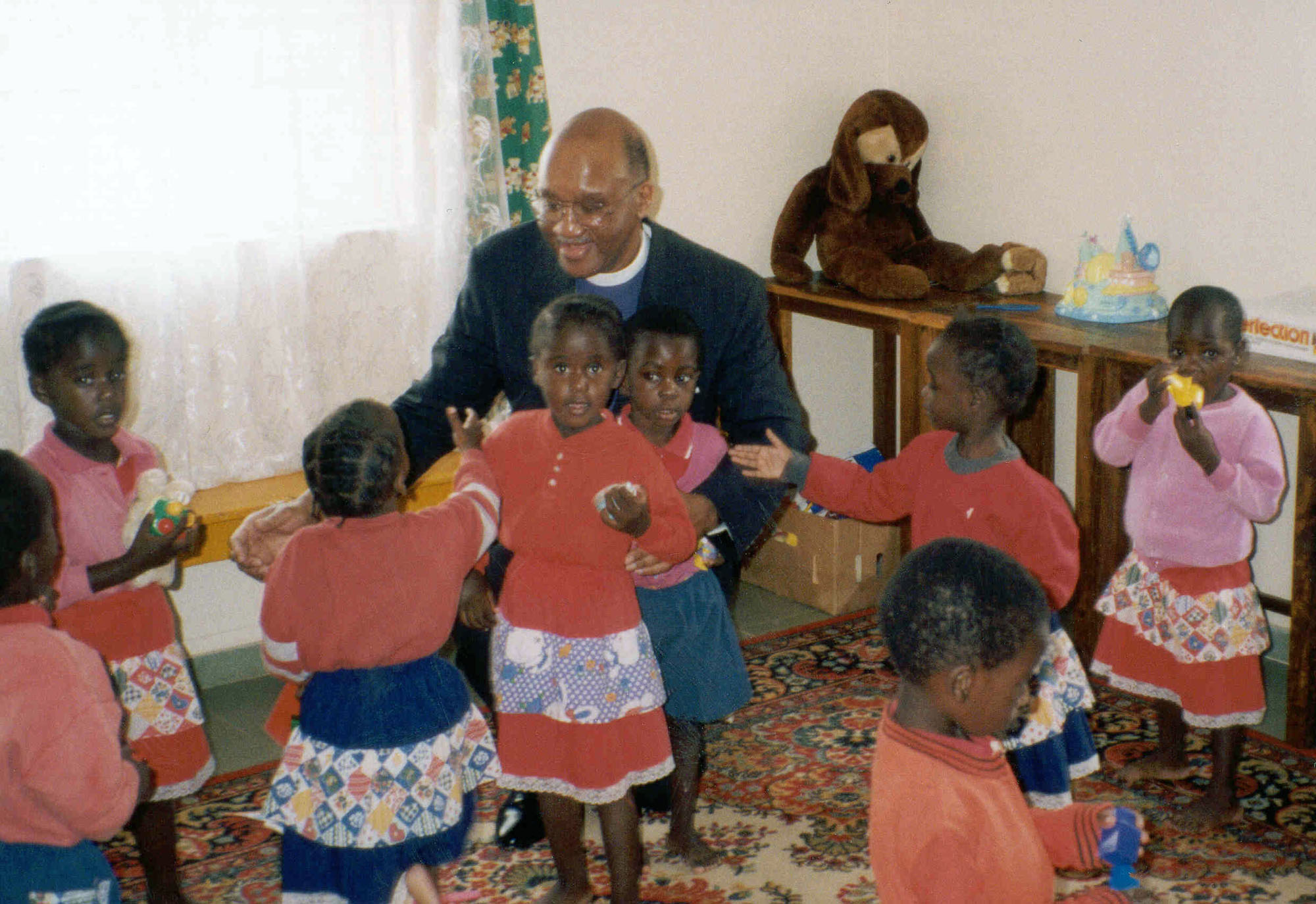 United Methodist Bishop Felton May plays with children at a Zambian orphanage in 1999 during a trip in support of a Presidential Mission on Children and AIDS.  The trip 