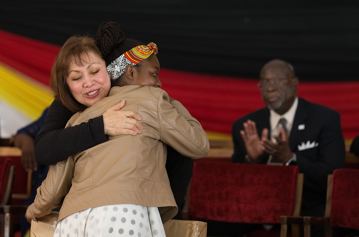 Bishop Minerva Carcaño (left) hugs Chiedza Chiwanza at the conclusion of Sunday worship during the 25th anniversary celebration for Africa University in Mutare, Zimbabwe. Chiwanza, a first-year humanities student, had just presented Carcaño a gift. At right is Bishop James Swanson. Photo by Mike DuBose, UMNS.
