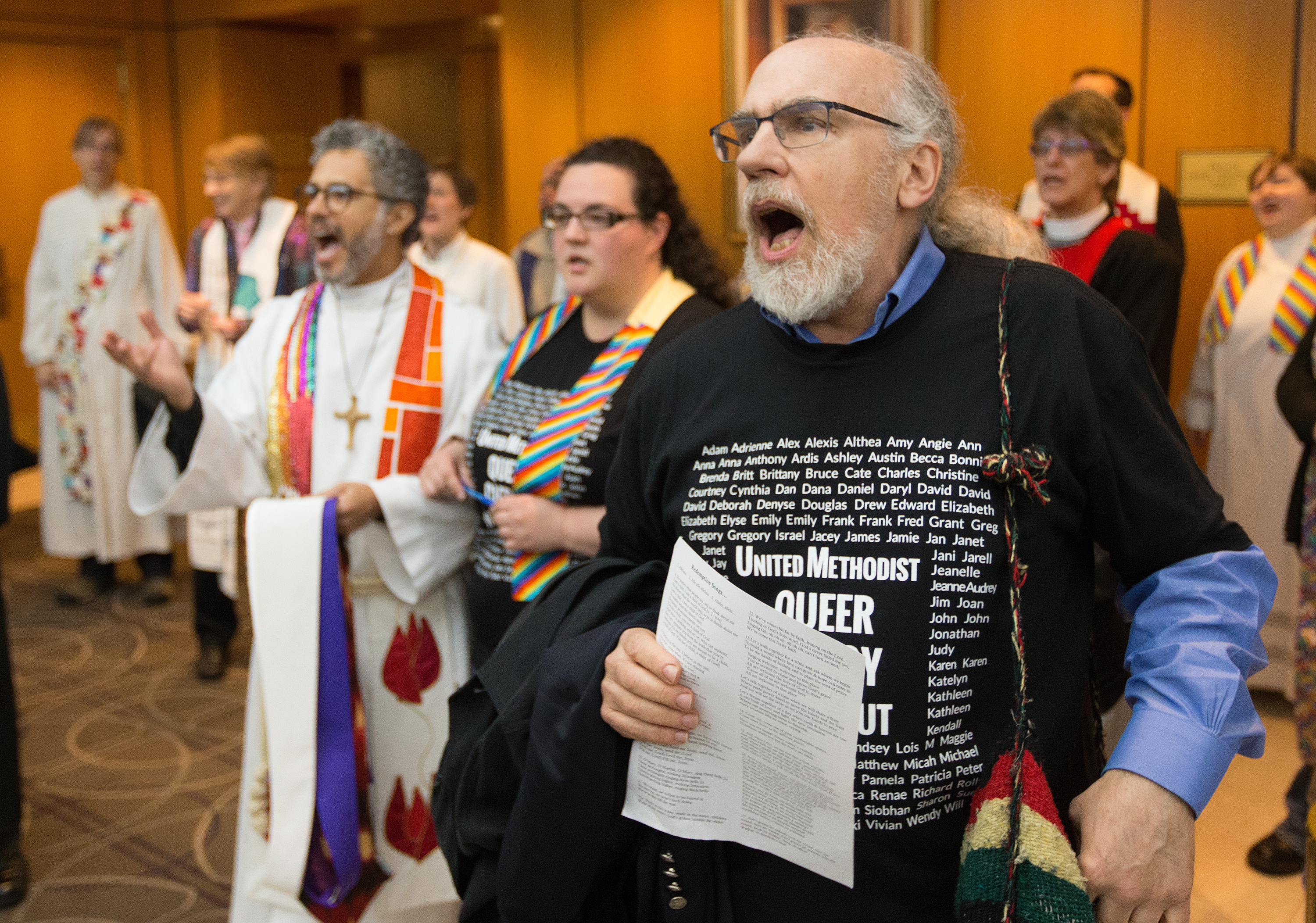 The Rev. K Karpen (right) of St. Paul and St. Andrew United Methodist Church in New York leads a song prior to an oral hearing before the denomination's top court, meeting in Newark, N.J., questioning whether a gay pastor can serve as a bishop in The United Methodist Church. Photo by Mike DuBose, UMNS.