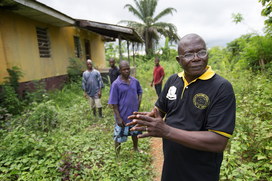 The Rev. Joseph Theoway (front) describes his vision for the restoration of the Liberian Annual Conference’s agricultural center in White Plains, which was destroyed during the country's civil war. Theoway is flanked by caretakers who are maintaining what is left of the facility. Photo by Mike DuBose, UMNS.