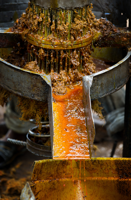 Palm oil runs from the hand-driven press at the United Methodist Ganta Mission Station in Ganta, Liberia. Photo by Mike DuBose, UMNS.