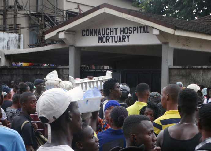 A crowd gathers at the main Freetown government Connaught Hospital Mortuary, where people wait for the chance to identify relatives. In the confusion and shock, not many had the opportunity to go in. More and more bodies were brought in as security forces tried to control the crowd and keep order. Photo by Phileas Jusu, UMNS.  