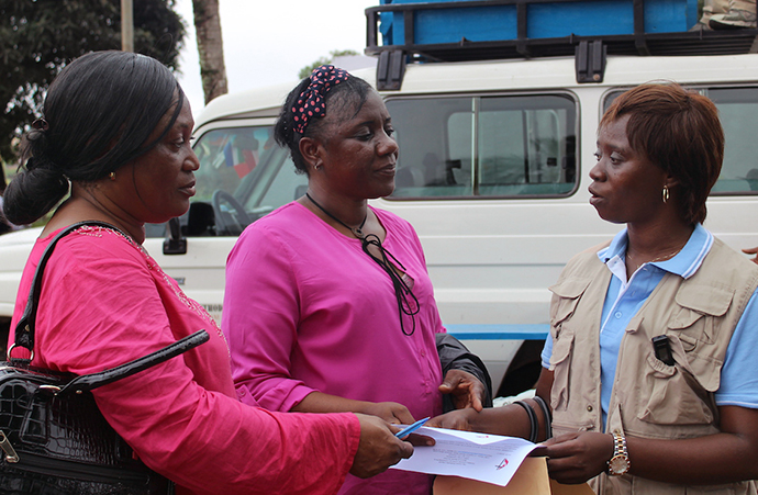 Sierra Leone Annual Conference Health Coordinator Catherine Norman (right) confers with government health representatives at one of the relocation centers where people displaced by the Aug. 14 disaster can seek help. Photo by Julu Swen, UMNS.