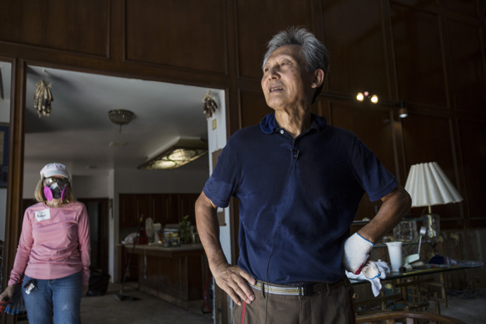 An emotional Dan Cho describes the extensive flood damage to his Houston home as Anne Thomas, of the city's Chapelwood United Methodist Church, stands by. Chapelwood has had teams mucking out homes flooded in the aftermath of Hurricane Harvey, and Thomas was part of a team working at Cho's on Sept. 11. Photo by Kathleen Barry, UMNS.