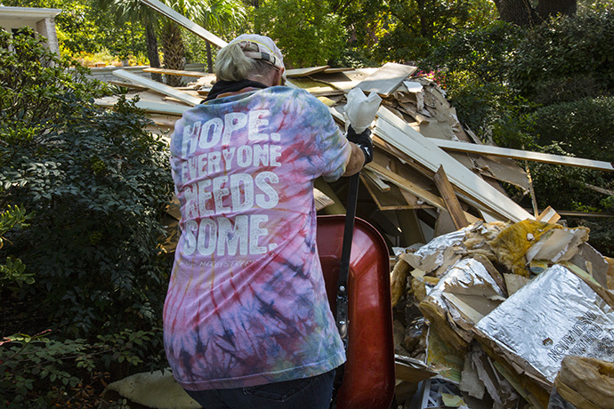 Helen Crowe from Chapelwood United Methodist Church in Houston dumps a load of debris in the front yard of a home flooded by Hurricane Harvey. Photo by Kathleen Barry, UMNS.