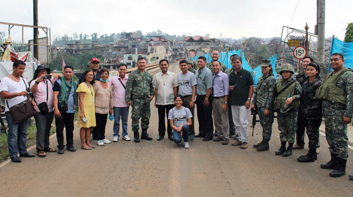 A United Methodist mission team stands at the Mapandi Bridge where the fiercest battle between government troops and the Maute happened. Photo courtesy of the Rev. Capt. Eduardo Copliting.