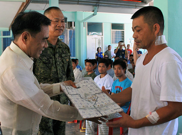 Bishop Rodolfo A. Juan (left), gives a set of pajama to an injured soldier during a two-day relief effort by Filipino United Methodists for wounded military and people displaced by violent conflicts in the Philippines. Photo courtesy of the Rev. Capt. Eduardo Copliting.