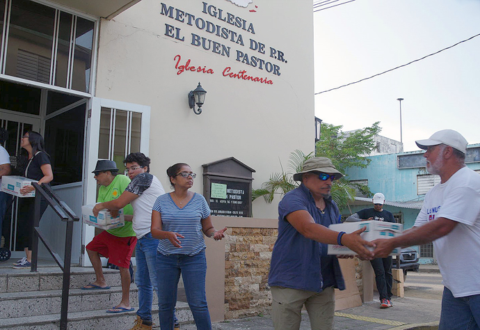 A group of members and pastors from Methodist churches in the San Juan area form a human chain to unload supplies at the Utuado church in central Puerto Rico. The 