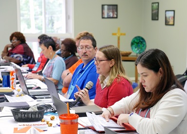 Sara Hotchkiss, in red, speaks during the Commission on General Conference meeting Oct. 7 at Camp Sumatanga in Gallant, Ala. Earlier in the meeting, Hotchkiss helped explain plans for the special General Conference in 2019. Photo by Heather Hahn, UMNS. 