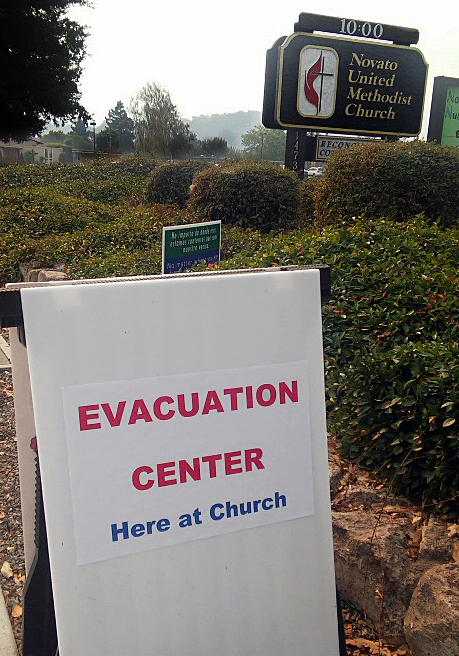 An evacuation sign posted by Novato United Methodist Church in Novato, California, shows the way for those seeking shelter after deadly wildfires broke out across the state, Oct. 9. The church hosted about 60 people during the day on Monday and 50 overnight. Photo courtesy of Novato United Methodist Church.