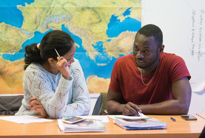 Recent immigrants Swapna (left) from India and Richard from Ghana work on exercises in their German class at the United Methodist Church of the Redeemer in Bremen, Germany. Photo by Mike DuBose, UMNS.