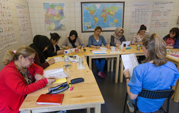 Carolin Hein (right foreground) conducts a German language class for refugees at the United Methodist headquarters in Frankfurt, Germany.