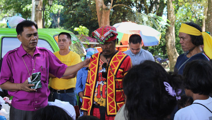 Bishop Rodolfo A. Juan (left) prays for a leader (red vest) at a refugee camp in Malaybalay, Philippines. United Methodists pooled their resources to provide relief to wounded soldiers and people displaced due to violence between the military and the Islamic State group or ISIS. Photo courtesy of Dan Ela.