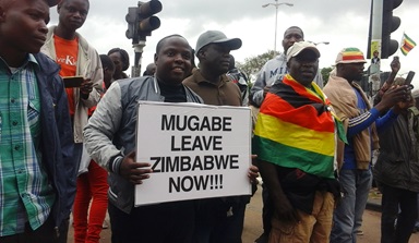 Crowds in Harare, Zimbabwe, carried signs and chanted “Mugabe must go” after the military there placed President Robert Mugabe under house arrest.