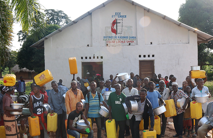 Beneficiaries of supplies stand in front of the local church in the Kasongo-Samba District. In the East Congo Episcopal Area, Connexio, a network for service of The United Methodist Church of Switzerland and France, has helped the episcopal area provide aid to Kabambare territory residents who fled following the insurrection of Mai Mai Malaika rebels. Photo by Judith Osongo Yanga, UMNS.