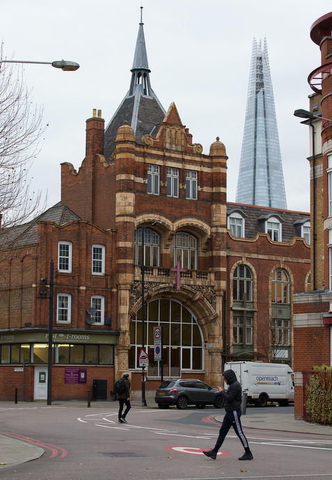 Bermondsey Central Hall Methodist Church serves a diverse congregation of about 250 and houses the South London Mission, which has been supporting the community since 1889. The modern London Shard skyscraper rises behind the church.