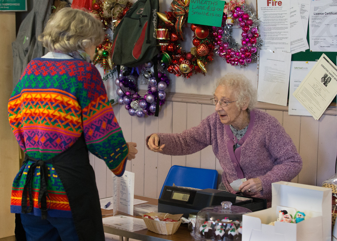 Muriel Reade (right), 88, serves as cashier and treasurer during the community café. Photo by Mike DuBose, UMNS.