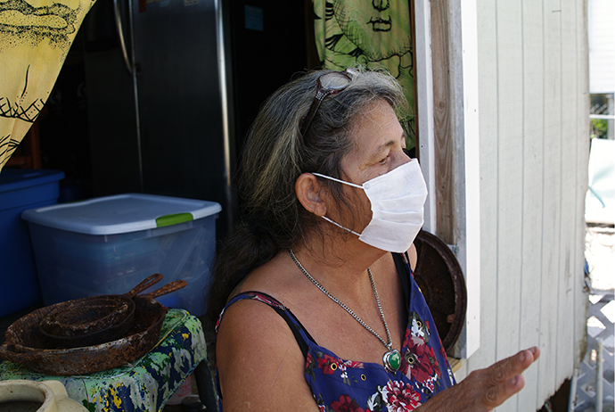 Donna Allison, a resident of Big Pine Key, Fla., has to wear a mask when she leaves her trailer, due to mold growing in the abandoned home next to hers. Photo by Gustavo Vasquez, UMNS.