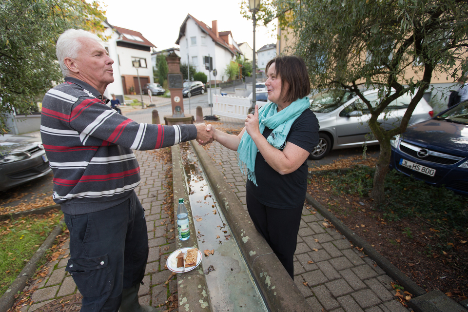 The Rev. Heike Miller (right) visits with Dieter Kugelmann outside the United Methodist Church in Lorsbach, Germany, during Café Gegenüber, a weekly gathering for coffee, cake and conversation. Photo by Mike DuBose, UMNS.