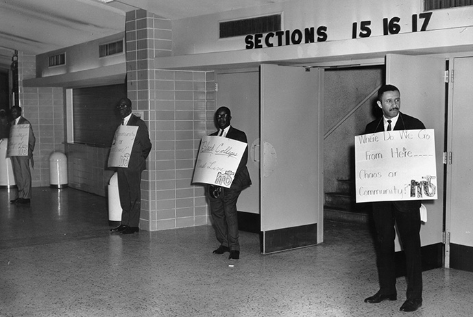 “Where do we go from here… Chaos or Community?” appears on the sign held by the Rev. Gilbert H. Caldwell by the entrance to the plenary for the 1968 Uniting Conference in Dallas. The phrase is the title of the Rev. Martin Luther King Jr.’s final book, and a reminder of the church's ongoing call to confront racism. Photo courtesy of the Archives and History.