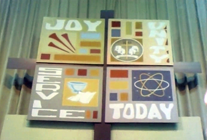 A banner proclaiming JOY, UNITY, SERVICE, TODAY hangs above the altar in the plenary space of the 1968 Uniting Conference in Dallas. Screenshot from 1968 Television, Radio and Film Commission video.