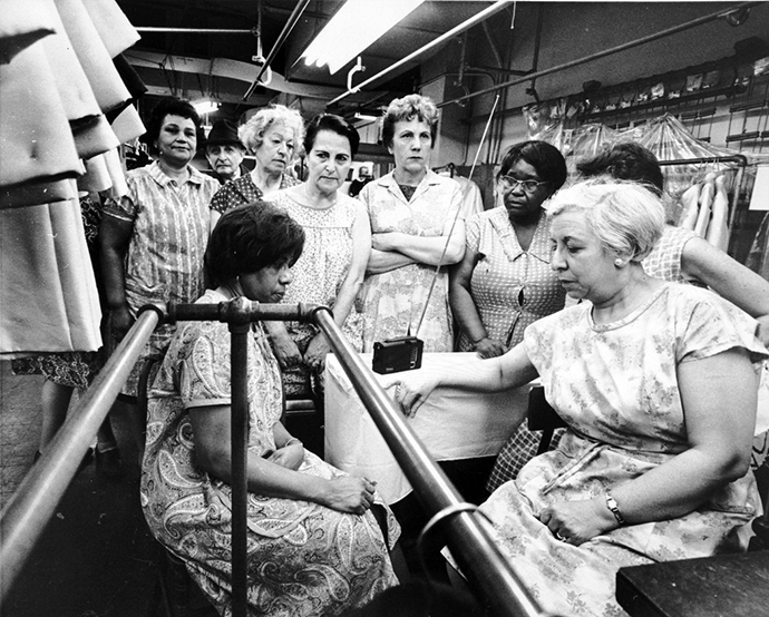 Garment workers at the Abe Schrader Shop listen to the funeral service for the Rev. Martin Luther King Jr. on a portable radio, April 8, 1968. Photo courtesy of Kheel Center, Cornell University, via Wikimedia Commons.