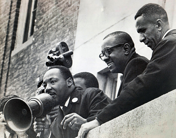 The Rev. Gilbert H. Caldwell (right) stands with the Revs. Martin Luther King Jr. (left) and Virgil Wood on the roof of a Boston public school in 1965. Photo courtesy of the Rev. Gilbert H. Caldwell.