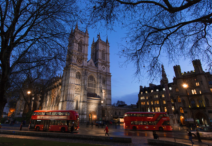 Double-decker buses drive past Westminster Abbey in London, across the street from Methodist Central Hall, Westminster. Photo by Mike DuBose, UMNS.