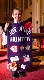 Luke Altman, 4, holds a banner honoring Joe Anne Hunter.