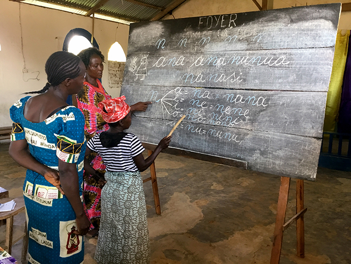 Three of the students work on vowels at a chalkboard during training for the wives of theology students at Kindu United Methodist University in Democratic Republic of Congo. Photo by Judith Osongo Yanga, UMNS.