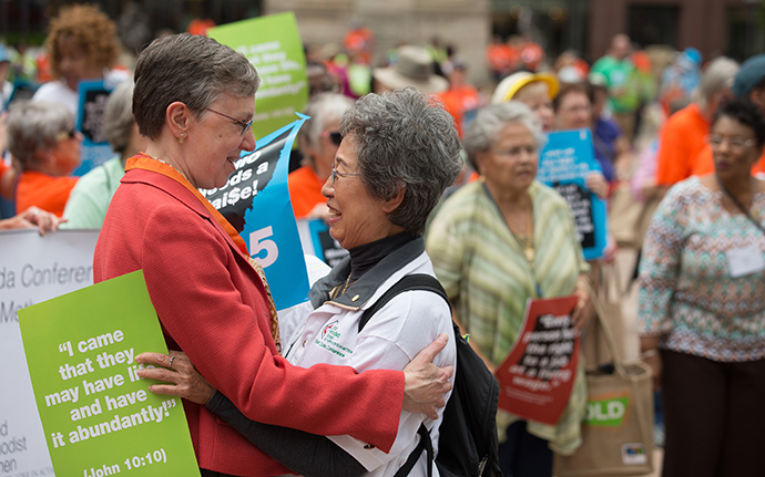 Harriett Jane Olson (left), United Methodist Women chief executive officer, greets Kyung Za Kim during a rally for a fair living wage on the steps of the Ohio Statehouse in Columbus during the United Methodist Women Assembly 2018. Kim is a previous national president of the organization. Photo by Mike DuBose, UMNS.