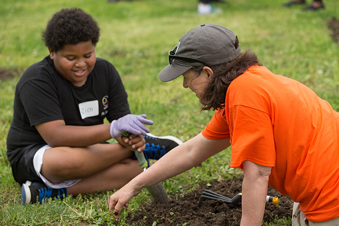 Janet Jonas (right) and Freedom Scholar Rico prepare a garden bed for planting with Rico, a student at the All People Children’s Defense Fund Freedom School at Lincoln Park Elementary School in Columbus, Ohio, as part of the Ubuntu Day of Service at the United Methodist Women Assembly 2018 in Columbus, Ohio. Photo by Mike DuBose, UMNS.
