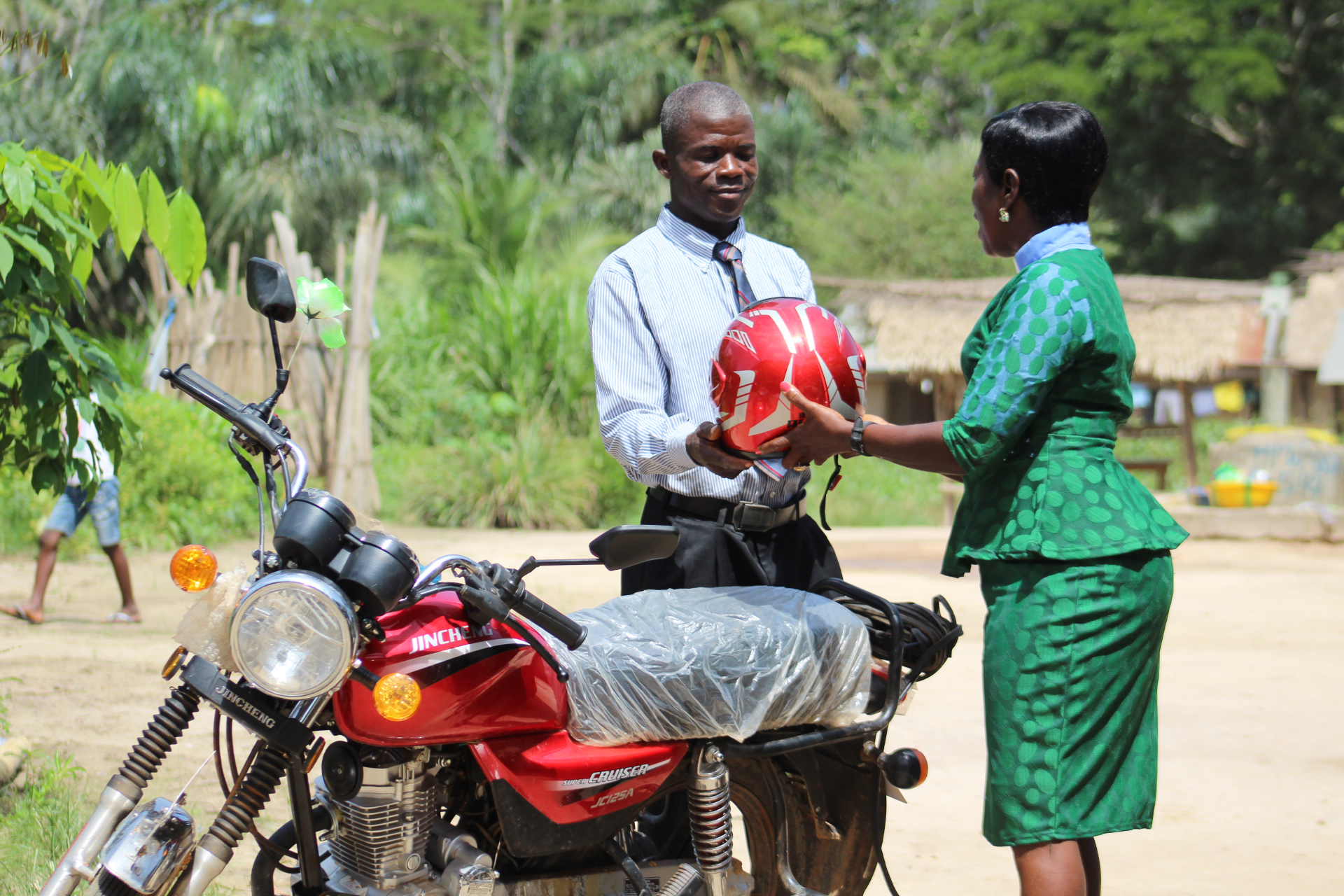 The Rev. Cecelia Marpleh, district superintendent for the Liberia Conference, presents a motorbike to Pastor William Kulah for his travels to Gbanjuloma United Methodist Church each week. With the motorbike, it takes him five hours to get to his assigned church. Photo be E Julu Swen, UMNS.