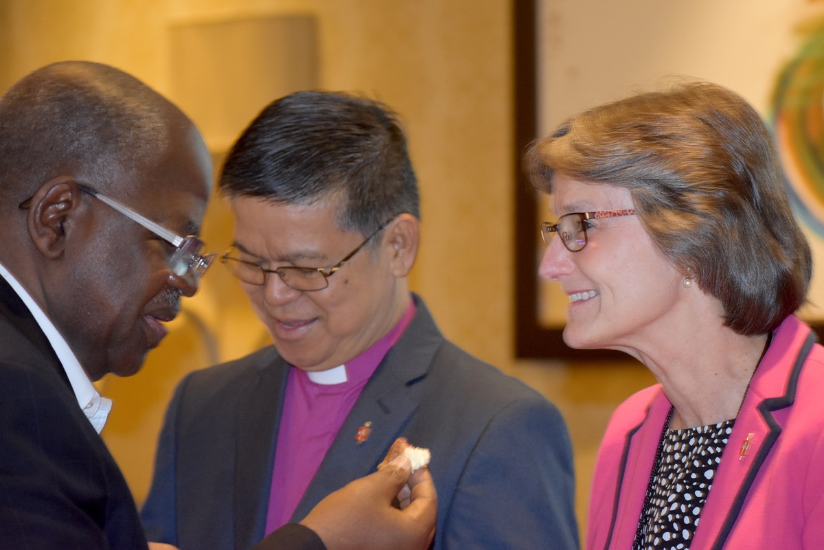 From left, Bishop David Yemba takes communion from Bishops Ciriaco Q. Francisco and Sandra Steiner Ball on May 3 during the meeting of the Council of Bishops in Chicago. Photo by Heather Hahn, UMNS.