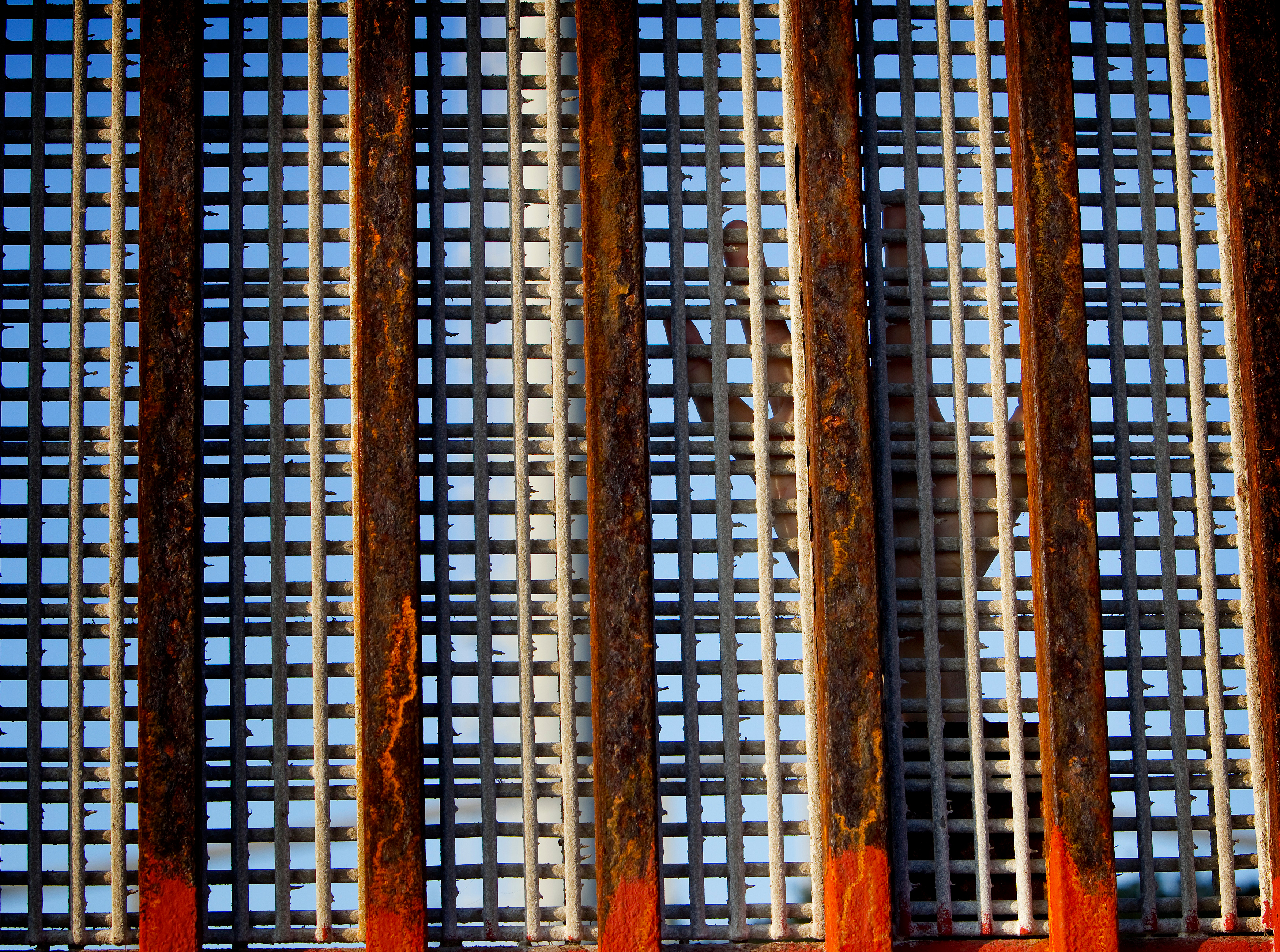 A person standing in the United States reaches their hand toward Mexico along the border fence at El Faro Park in Tijuana, Mexico, in 2012. United Methodists are joining opposition to a new “zero tolerance” policy that is separating immigrant families. File photo by Mike DuBose, UMNS.
