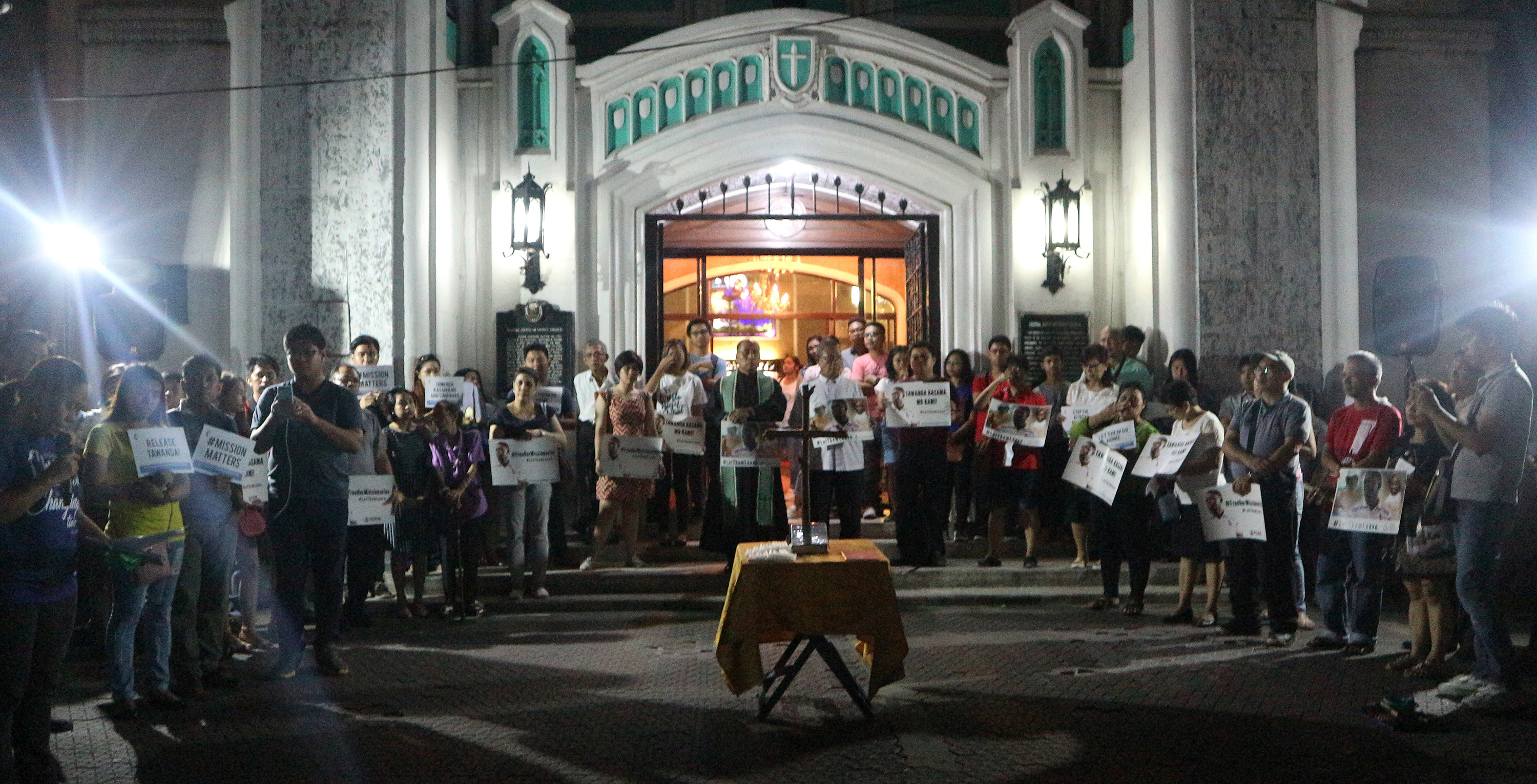 A crowd holds signs outside Central United Methodist Church in Manila in support of the missionaries from the United Methodist Board of Global Ministries detained by the Philippine’s government. Photo courtesy of Gladys Mangiduyo, UMNS.