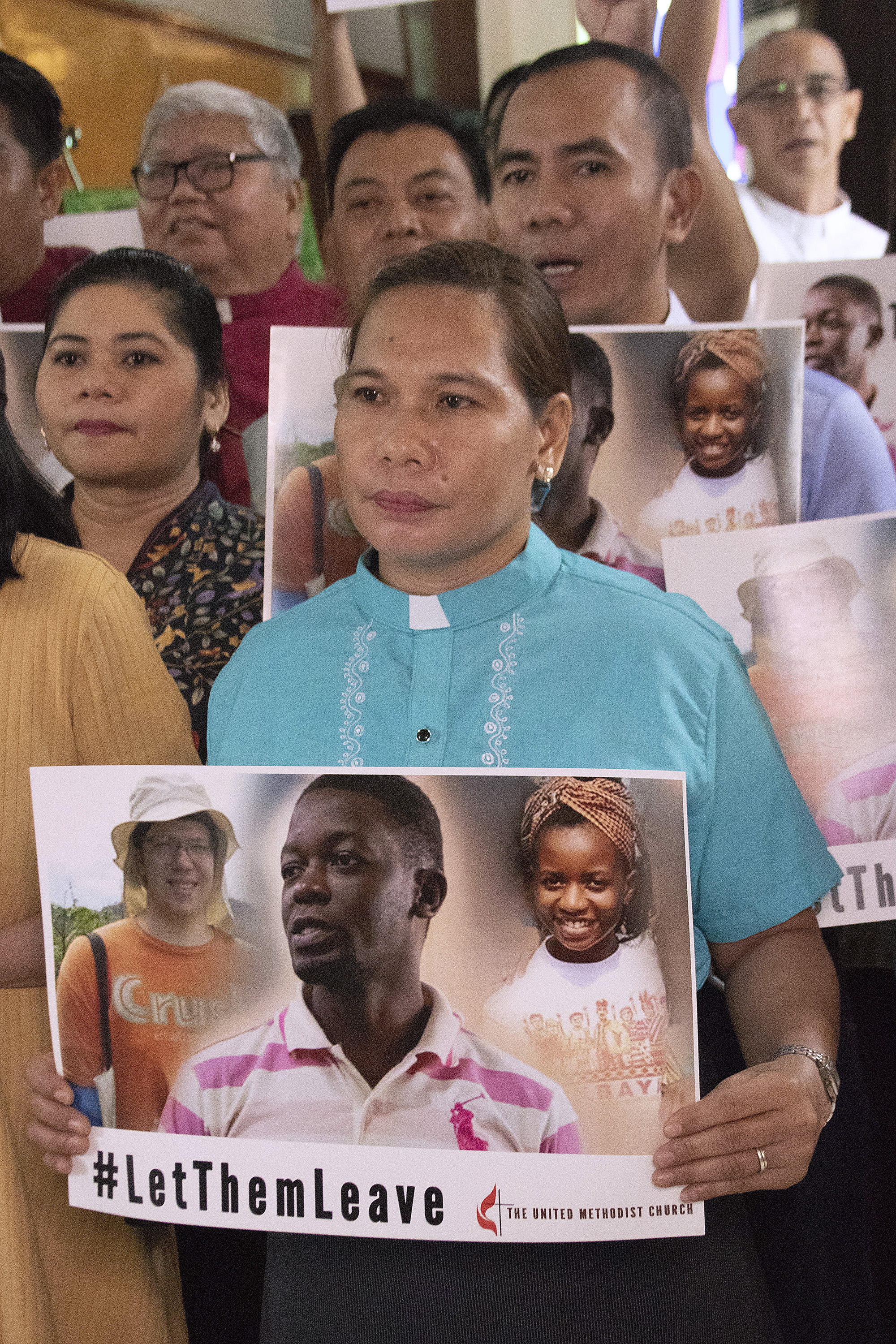A clergywoman holds a poster seeking the release of detained missionaries Tawanda Chandiwana and Miracle Osman. A third missionary, Adam Shaw, was expelled and will return to Ohio. Photo by Jan Snider, UMCom.