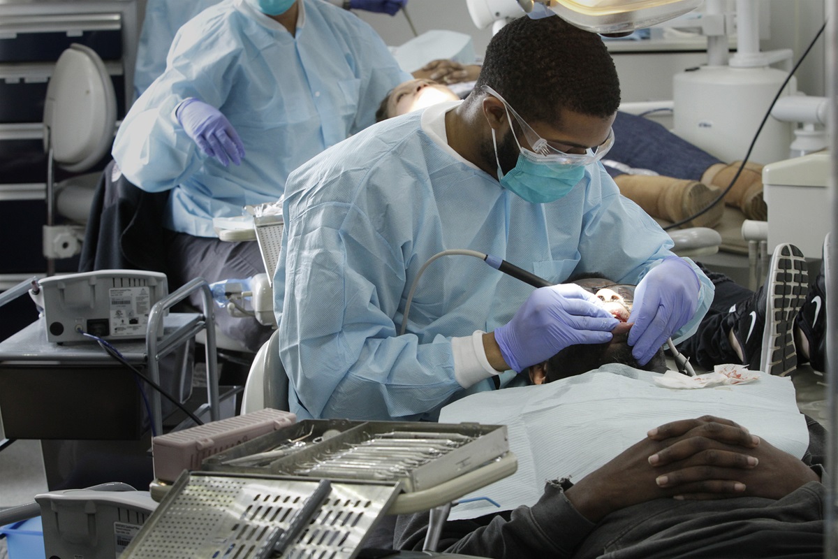 La estudiante de odontología Preston Harris examina a un paciente en la clínica dental móvil de la Universidad Médica Meharry en Nashville, Tenn.