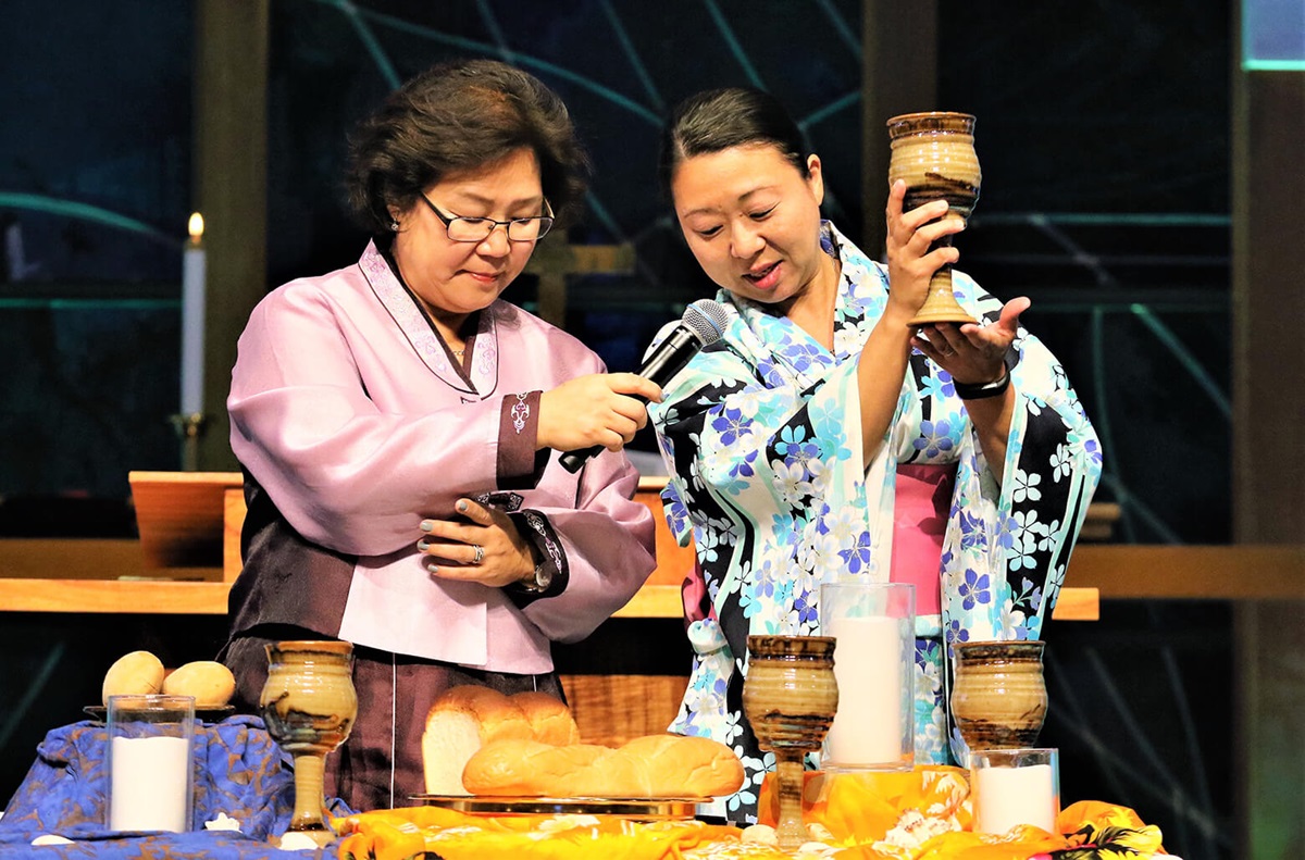 The Revs. Pauline Hyekyoung Kang (left) and Motoe Yamada Foor lead the Holy Communion prayer at the opening worship service of the 2018 Ohana Conference. Photo by the Rev. Thomas Kim, UMNS.