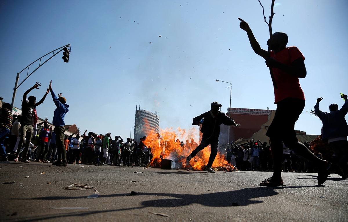 Supporters of the opposition Movement for Democratic Change party block a street on Aug 1 in Harare, Zimbabwe. In the wake of soldiers opening fire on the protesters, United Methodist bishops and other church leaders called for prayers for peace. REUTERS/Siphiwe Sibeko. Do not reuse. One Time Use.